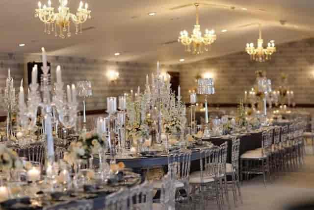 Lux wedding banquet at Legacy Ottoman Hotel featuring crystal candelabras and ghost chairs.