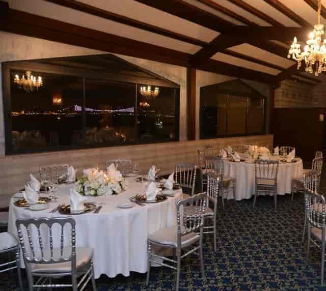 Ottoman Salon gala setup with silver chairs, waterfront view, luxury event venue, banquet hall.