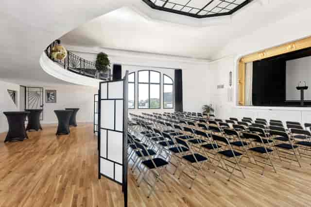 Art Deco event venue with stage and networking area for corporate presentations and conferences.