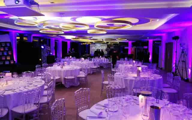 Banquet-style function room at Pavillon Royal with purple uplighting for evening gala events.