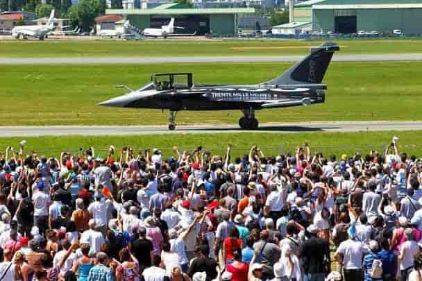 Crowded Paris Air Show outdoor exhibition halls, professional trade show event marketing.