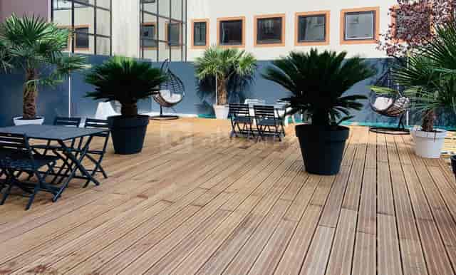 Wooden terrace at Le Meeting Place, ideal for outdoor networking events and coffee breaks.