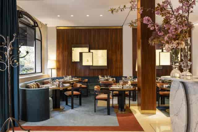 Fireplace corner at Hôtel Montalembert: upscale wood-paneled space for corporate dinners or lunches.