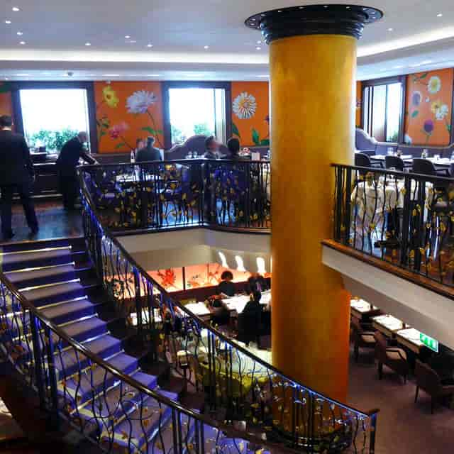 Split-level dining room at 114 Faubourg with floral wall decor for corporate events and gala dinners.