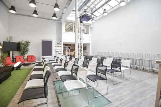 Industrial-chic meeting room with theater seating for professional presentations and workshops.