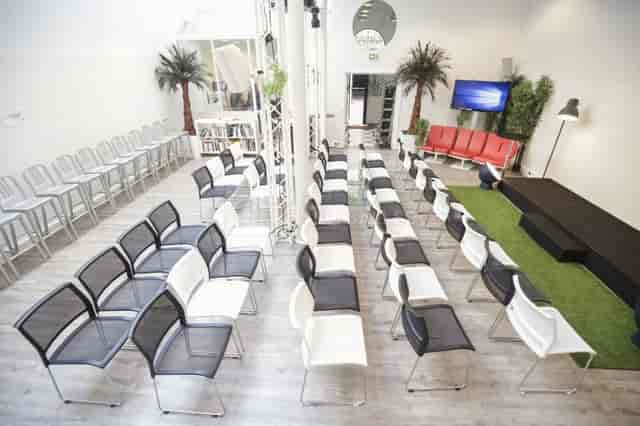 Modern HUBLOFT conference room with artificial turf stage for corporate workshops and panels.