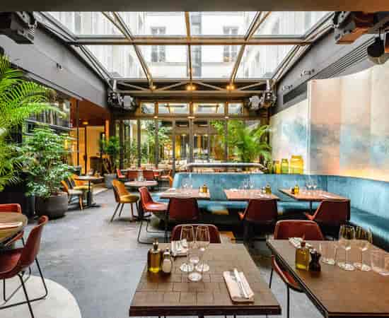 Hôtel National des Arts & Métiers atrium with lush greenery for corporate luncheons and receptions.