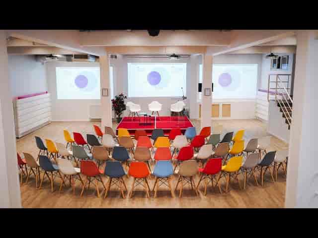 Modern Espace Batignolles conference venue with colorful chairs for panel discussion event.