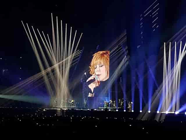 Concert at Paris La Défense Arena with beam lighting and LED screens for live event entertainment.
