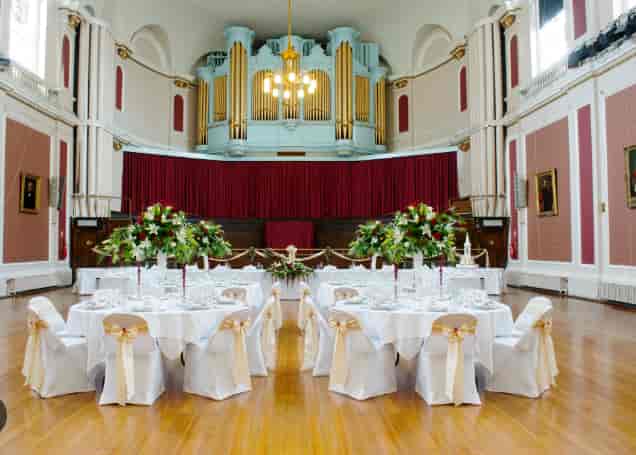 Large Hall venue with pipe organ, set for formal wedding banquet and elegant corporate event.