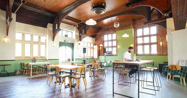 Modern cafe area in KL Youth Community Centre with heritage timber for networking and events.