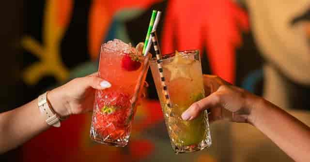 Networking mixer attendees toasting with cocktails at a chic terrace event venue.