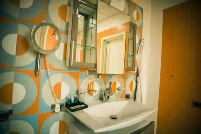 Mid-century tile bathroom at Badam d'Art Hotel, ideal for corporate event room blocks.