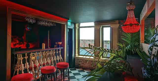 Private Hire VIP lounge with gold bar and red lighting, ideal for networking and cocktail events.