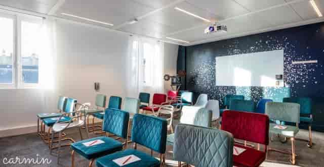 Theater-style breakout room with vibrant seating for corporate meetings and event venue spaces.