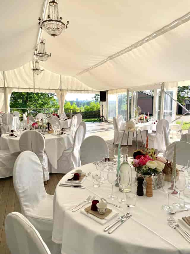 Elegant tented event setup at Kungliga Borgen with floral centerpieces for weddings and galas.