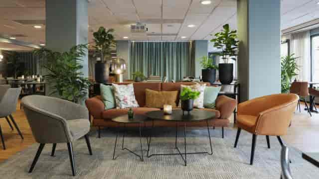 Modern hotel breakout space with biophilic design for corporate networking and conference events.