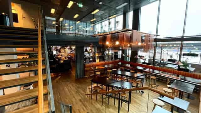 Industrial-chic Haga Bottega event space with floor-to-ceiling windows for corporate gatherings.