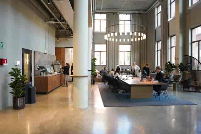 Modern coworking breakout space with boardroom table for networking and collaborative workshops.