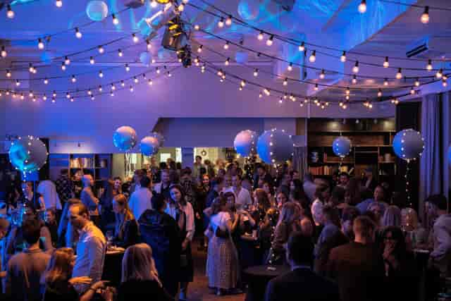Networking reception at VENUE81 with ambient festoon lighting for corporate events.