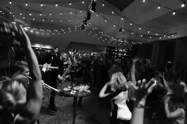 Live band performance at VENUE81 entrance bar with bistro lighting for corporate event reception.