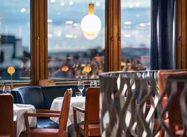 Upscale Gondolen cocktail bar: VIP dinner venue with city views and elegant banquette seating.
