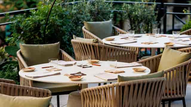 Upscale outdoor networking event at Orma Roma featuring ergonomic patio furniture.