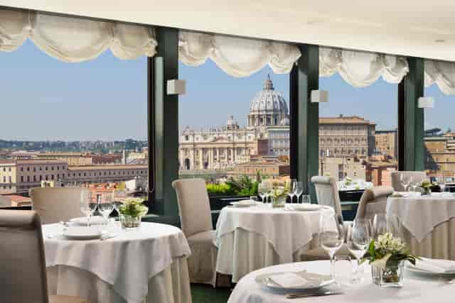 Luxury corporate dinner at Les Etoiles rooftop terrace with iconic Rome skyline views.