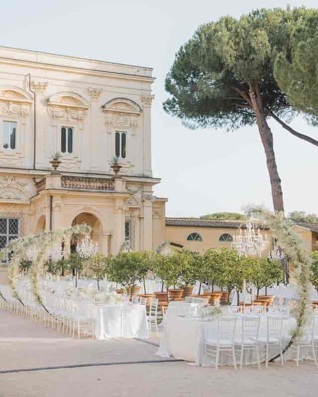 Luxury outdoor event at Villa Aurelia with classical architecture and manicured garden.