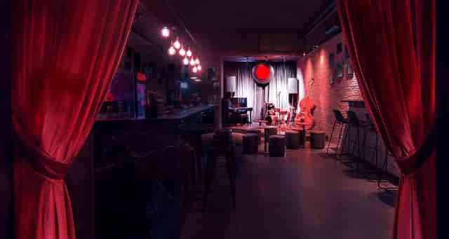 Moody rock club venue with red lighting for jazz showcases and private networking events.