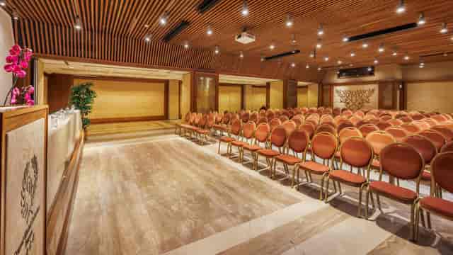 Theater-style conference room with wood-slatted walls for corporate seminars and presentations.