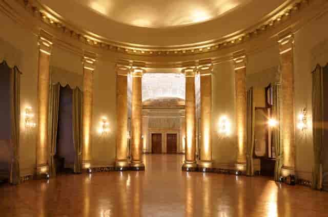 Neoclassical ballroom with architectural columns for black-tie gala and wedding venue events.