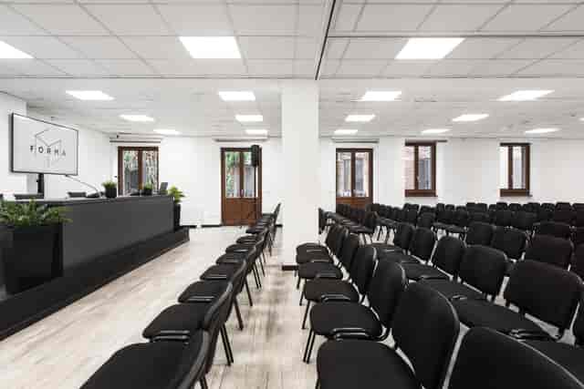 Minimalist Sala Q meeting room with AV stage for corporate training and seminars.