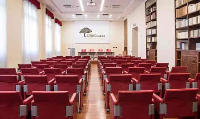 Auditorium Antonianum with red theater seating for academic lectures and professional presentations.