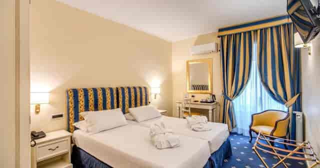 Hotel Napoleon twin room with classic decor for business conferences and event accommodation.