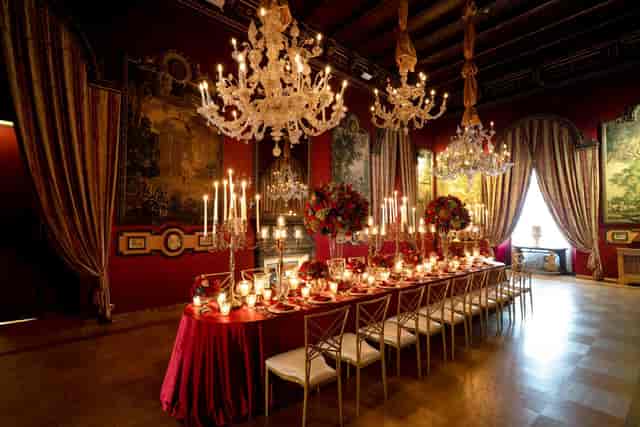 Formal dinner at Brancaccio Palace, Gala Hall with red lighting and crystal chandeliers.