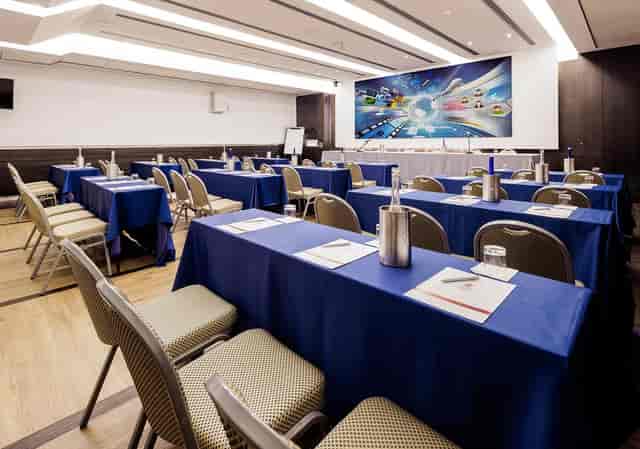 Schoolroom meeting room at Hotel Universo with blue linens for corporate events and conferences.