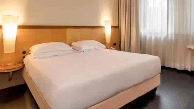 Upscale Mercure Eur Roma West suite with neutral decor, ideal for event lodging and VIP guests.