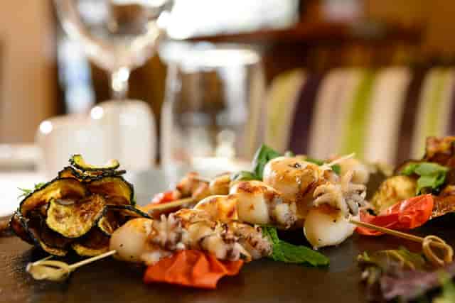 Grilled baby squid skewers at a VIP networking cocktail reception, UNA HOTELS Decò Roma.