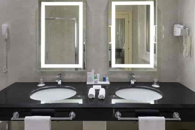 Luxury dual-vanity hotel bathroom at Empire Radisson Blu Rome for conference and event accommodation.