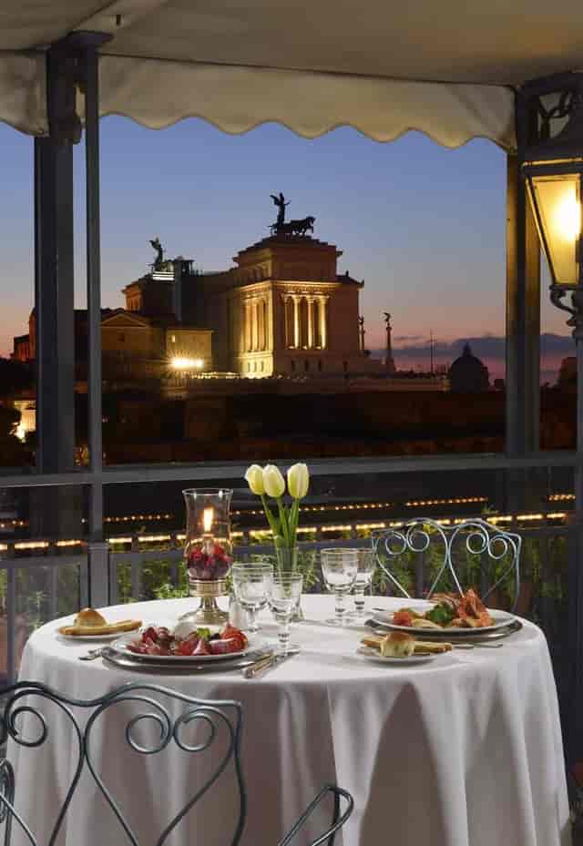 Upscale Penthouse terrace dining at Hotel Forum with illuminated Roman ruins for VIP gala events.