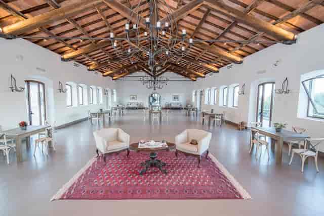 Rustic dining area with elegant chandeliers for corporate events and cocktail hours.