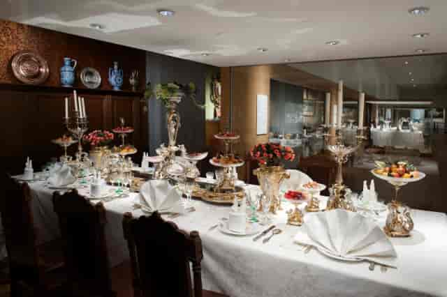 Formal banquet table setting with silver centerpieces for luxury corporate dinners and meetings.