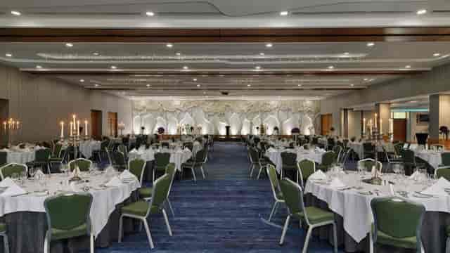 Ballroom gala setup with illuminated stage, perfect for elegant banquet and wedding events.