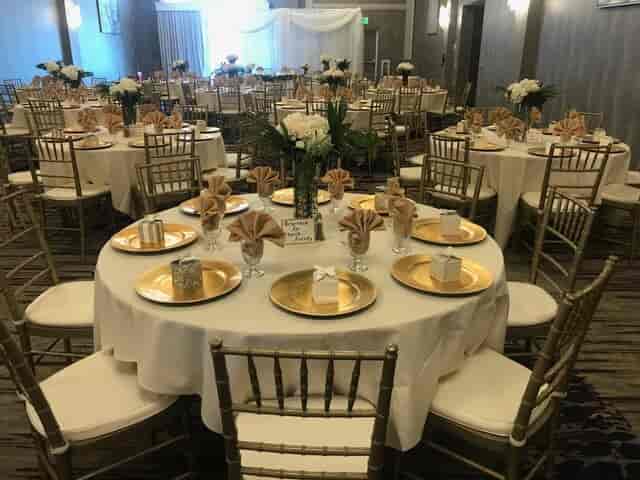 Elegant banquet hall with gold charger plates for corporate galas and wedding receptions.