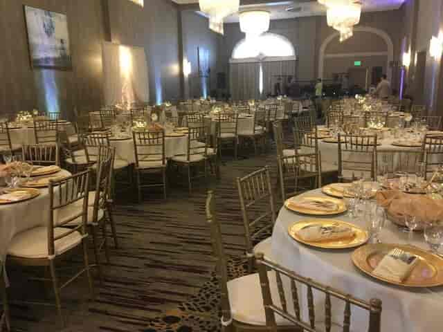 Elegant ballroom with gold Chiavari chairs for gala or wedding reception banquet.