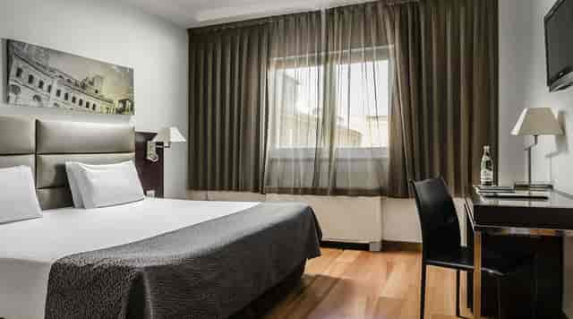 Sala Laura at Omnia Hotels: functional corporate guest room with workspace for business events.