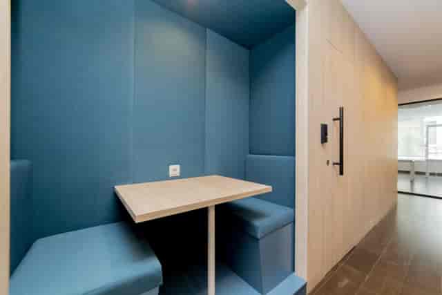 Modern huddle booth with acoustic panels for quiet office meetings and breakout sessions.