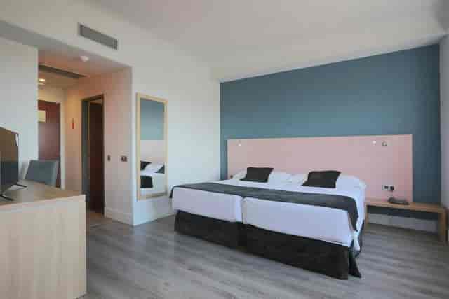Modern twin-bed hotel room at Alcala Hotel Chamartín for corporate event attendee accommodation.