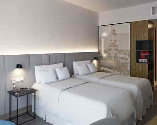 Modern hotel twin room at NH Iquique Pacífico for conference event accommodation.